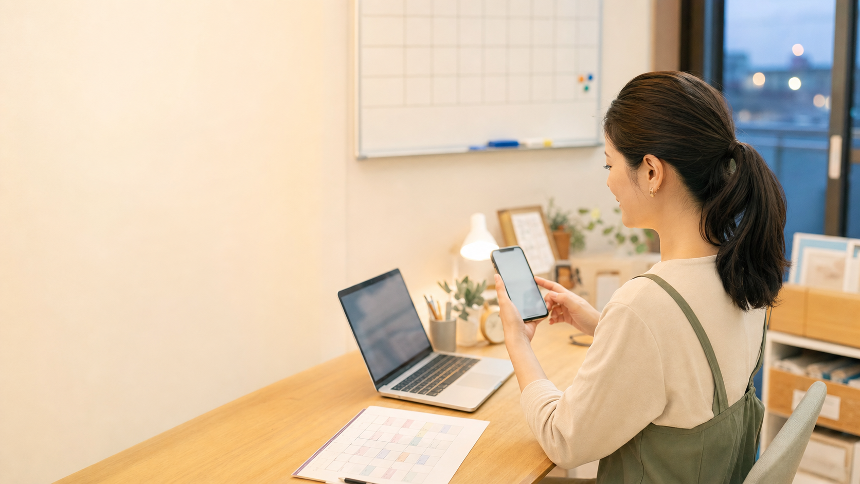 習い事教室の運営者がスマートフォンと予定表で予約対応を確認している様子